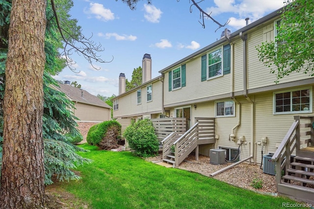 6880 E Appleton Cir, Centennial, CO 80112 - back of house featuring stairs, a lawn, central AC, and a chimney