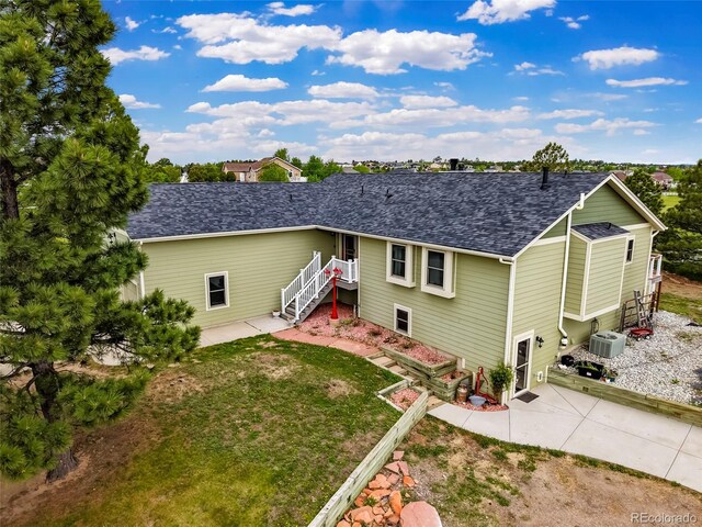 41504 Vista Rdg, Parker, CO 80138 - rear view of property with a shingled roof, central AC unit, and a lawn