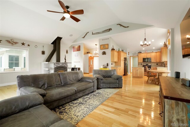 41504 Vista Rdg, Parker, CO 80138 - living area featuring a chandelier, vaulted ceiling, ceiling fan, light wood-type flooring, and a fireplace