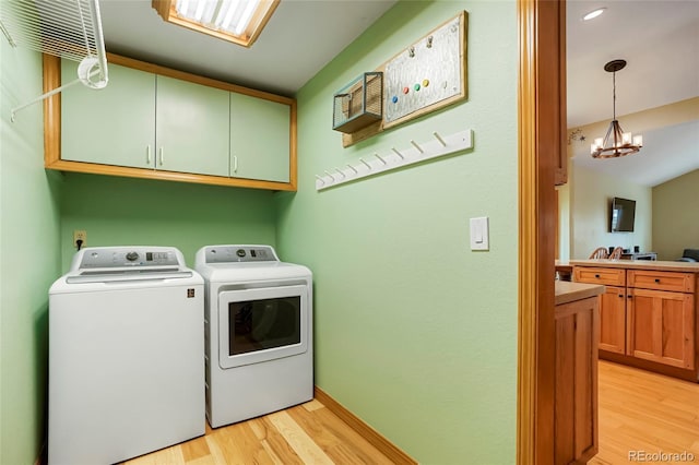 41504 Vista Rdg, Parker, CO 80138 - washroom featuring washing machine and clothes dryer, cabinet space, light wood-type flooring, a chandelier, and baseboards