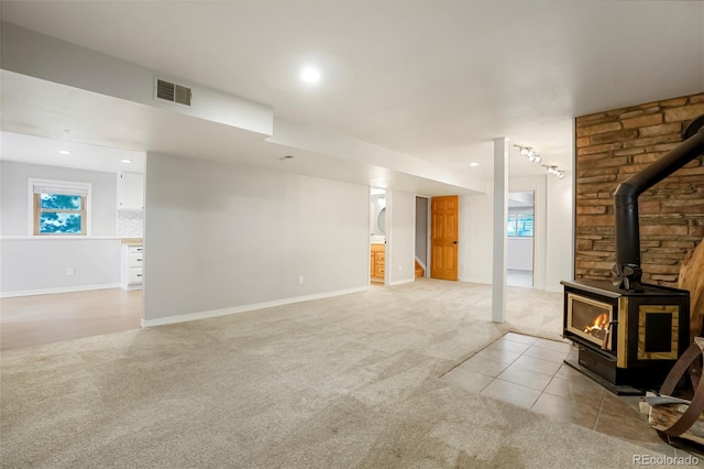 41504 Vista Rdg, Parker, CO 80138 - unfurnished living room with light colored carpet, a wood stove, baseboards, recessed lighting, and healthy amount of natural light