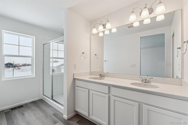 bathroom featuring wood-type flooring, vanity, and an enclosed shower