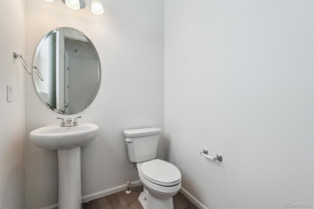 bathroom featuring wood-type flooring, toilet, and sink