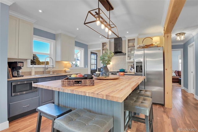 kitchen with sink, appliances with stainless steel finishes, a breakfast bar, and a kitchen island