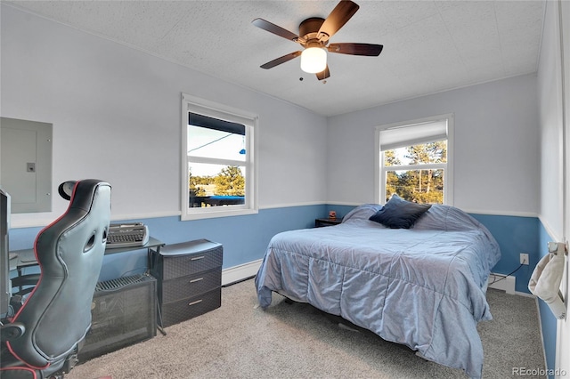 bedroom with a baseboard radiator, carpet, a textured ceiling, ceiling fan, and electric panel