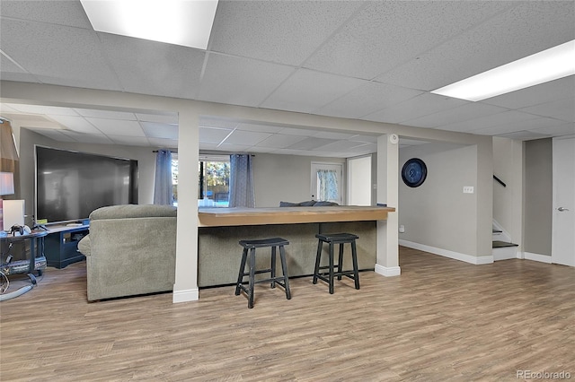 living room featuring a paneled ceiling and wood-type flooring