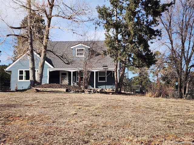 cape cod-style house with a shingled roof and a porch