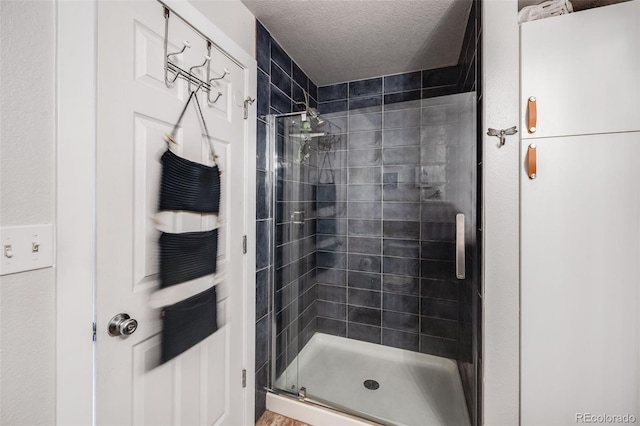 bathroom with a textured ceiling and walk in shower