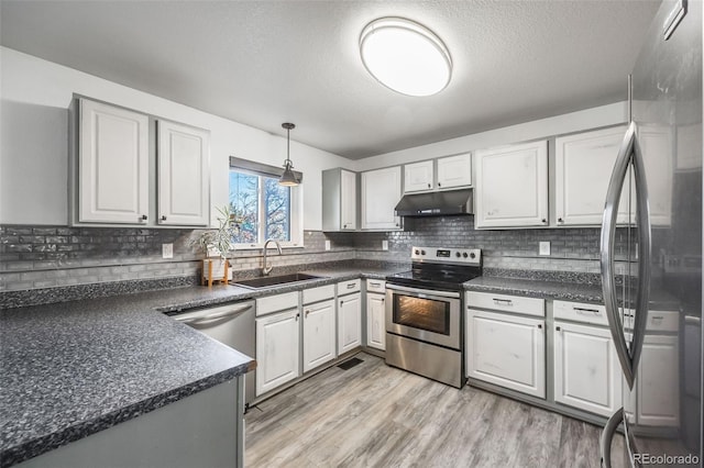 kitchen featuring white cabinetry, sink, light hardwood / wood-style flooring, and appliances with stainless steel finishes