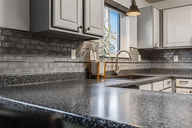 kitchen featuring white cabinetry, sink, and backsplash