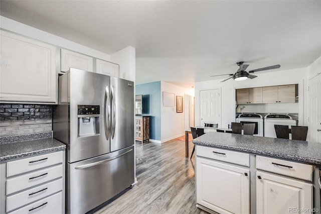 kitchen featuring white cabinets, washing machine and clothes dryer, ceiling fan, stainless steel refrigerator with ice dispenser, and light wood-type flooring