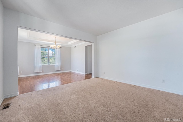 26004 E Elmhurst Pl, Aurora, CO 80016 - empty room with a chandelier, carpet floors, baseboards, a raised ceiling, and wood finished floors