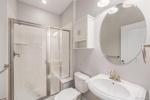 26004 E Elmhurst Pl, Aurora, CO 80016 - bathroom featuring toilet, a sink, a textured wall, and a stall shower