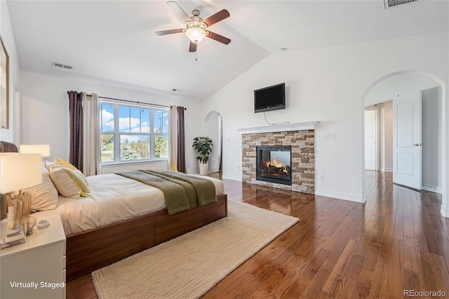 26004 E Elmhurst Pl, Aurora, CO 80016 - bedroom featuring arched walkways, vaulted ceiling, wood finished floors, a fireplace, and ceiling fan
