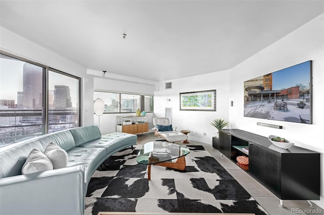 living room featuring light tile patterned floors, visible vents, and baseboards