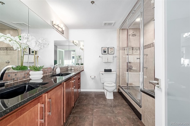 bathroom with a sink, visible vents, toilet, and a tile shower