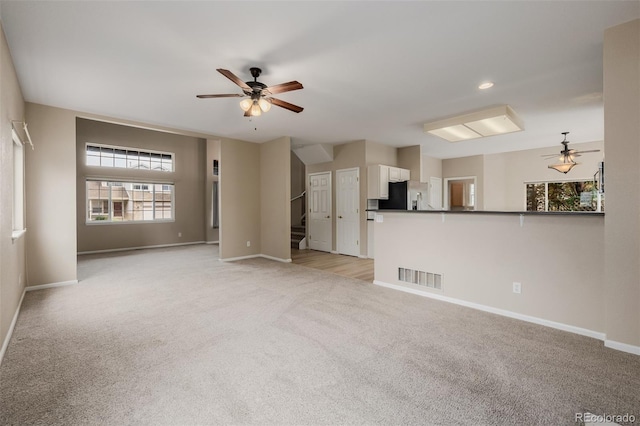 9417 Burgundy Cir, Highlands Ranch, CO 80126 - unfurnished living room with ceiling fan, light carpet, stairway, and recessed lighting