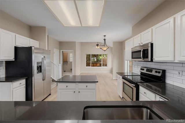 9417 Burgundy Cir, Highlands Ranch, CO 80126 - kitchen featuring appliances with stainless steel finishes, dark countertops, tasteful backsplash, white cabinets, and a ceiling fan