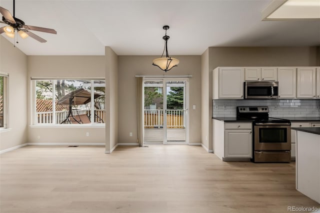 9417 Burgundy Cir, Highlands Ranch, CO 80126 - kitchen featuring dark countertops, stainless steel appliances, healthy amount of natural light, and light wood-style flooring