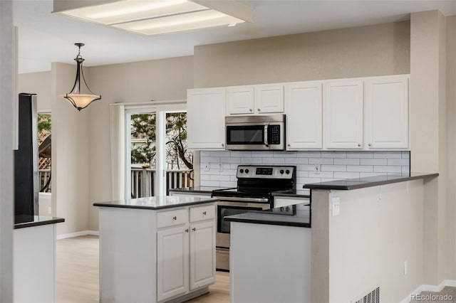 9417 Burgundy Cir, Highlands Ranch, CO 80126 - kitchen with dark countertops, stainless steel appliances, white cabinetry, and decorative backsplash