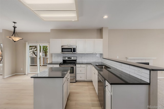 9417 Burgundy Cir, Highlands Ranch, CO 80126 - kitchen with dark countertops, stainless steel appliances, white cabinets, light wood finished floors, and a kitchen island