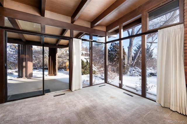 unfurnished sunroom with beam ceiling and plenty of natural light