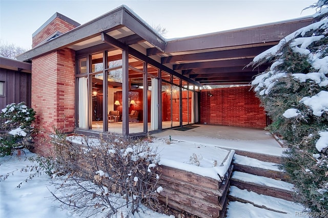 view of snow covered exterior with a carport