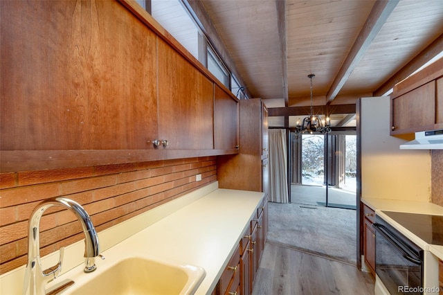 kitchen with sink, light hardwood / wood-style flooring, an inviting chandelier, electric range oven, and decorative light fixtures