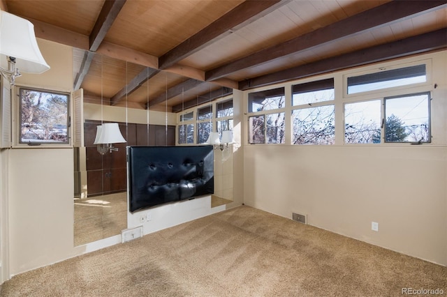 unfurnished living room featuring beam ceiling, carpet, and wood ceiling