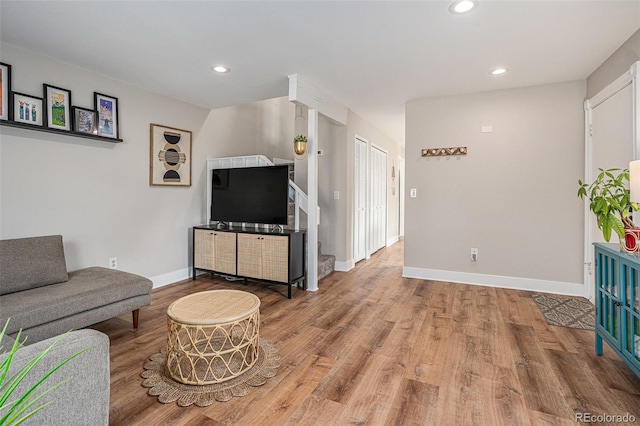 living room with recessed lighting, light wood-type flooring, and baseboards