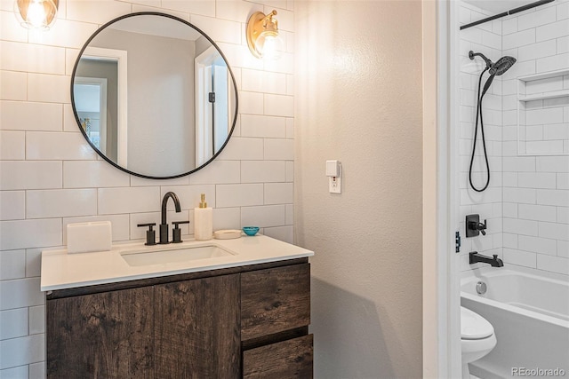 bathroom featuring toilet, backsplash, vanity, shower / bathtub combination, and a textured wall