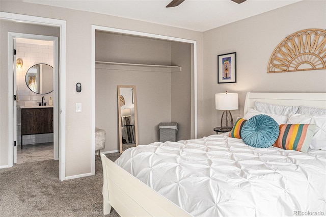 carpeted bedroom featuring a sink, a ceiling fan, a closet, and baseboards