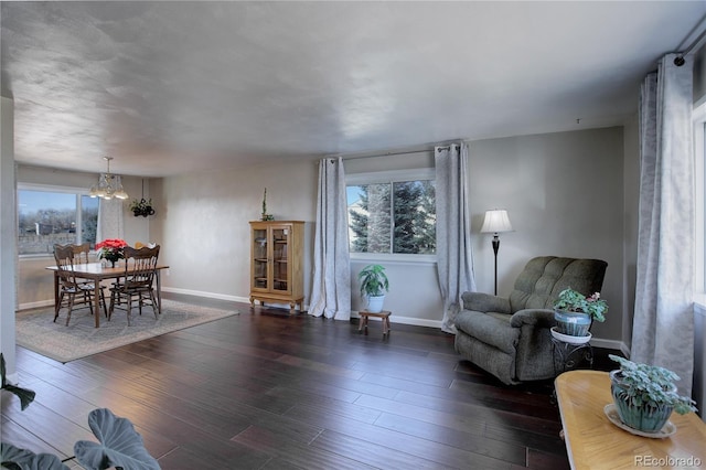 sitting room featuring dark hardwood / wood-style flooring, a wealth of natural light, and a notable chandelier