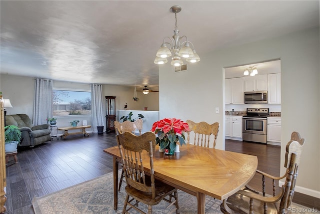 dining space with dark hardwood / wood-style floors and an inviting chandelier