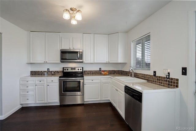 kitchen with dark hardwood / wood-style flooring, white cabinetry, sink, and stainless steel appliances