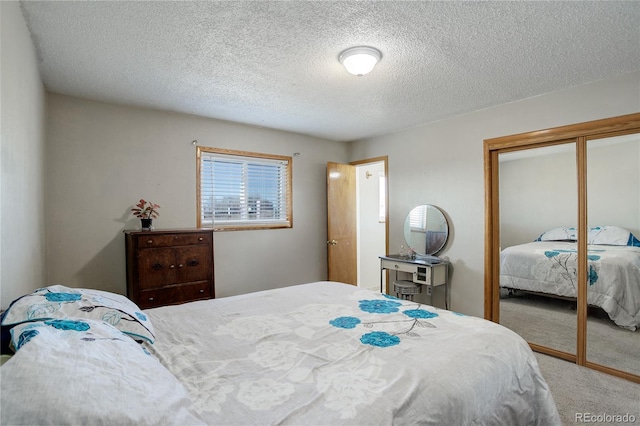 bedroom featuring carpet flooring, a closet, and a textured ceiling