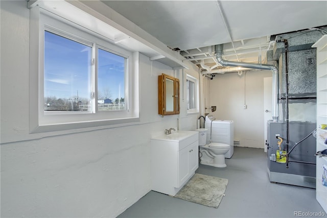 bathroom featuring vanity, concrete floors, toilet, and washing machine and clothes dryer