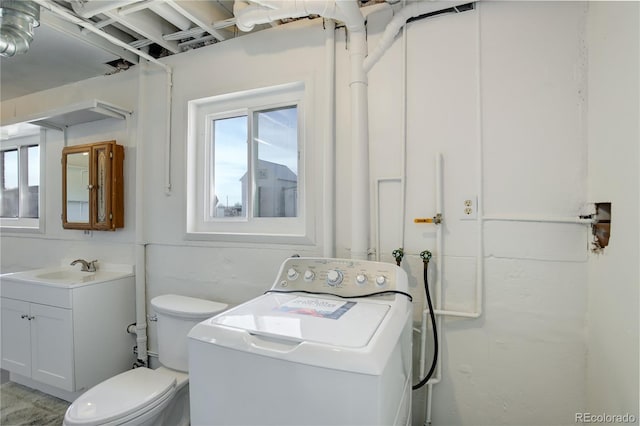 bathroom featuring vanity, washer / clothes dryer, and toilet