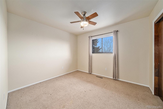 empty room featuring ceiling fan and light carpet