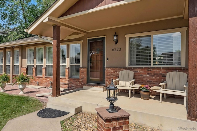 6223 W Flora Pl, Denver, CO 80227 - doorway to property with brick siding and a porch