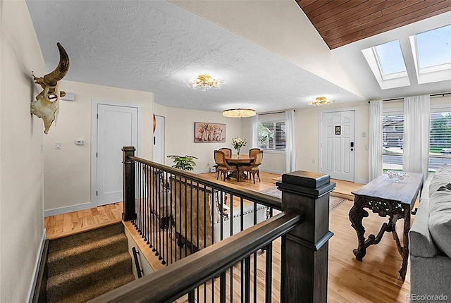 6223 W Flora Pl, Denver, CO 80227 - staircase with a skylight, plenty of natural light, wood finished floors, and vaulted ceiling
