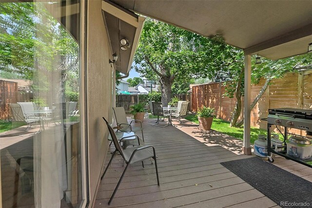 6223 W Flora Pl, Denver, CO 80227 - wooden deck featuring outdoor dining area and a fenced backyard