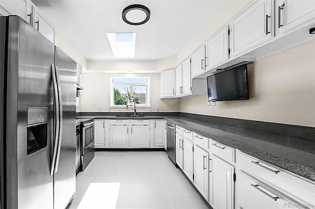 6223 W Flora Pl, Denver, CO 80227 - kitchen featuring stainless steel appliances, a sink, dark countertops, and white cabinetry