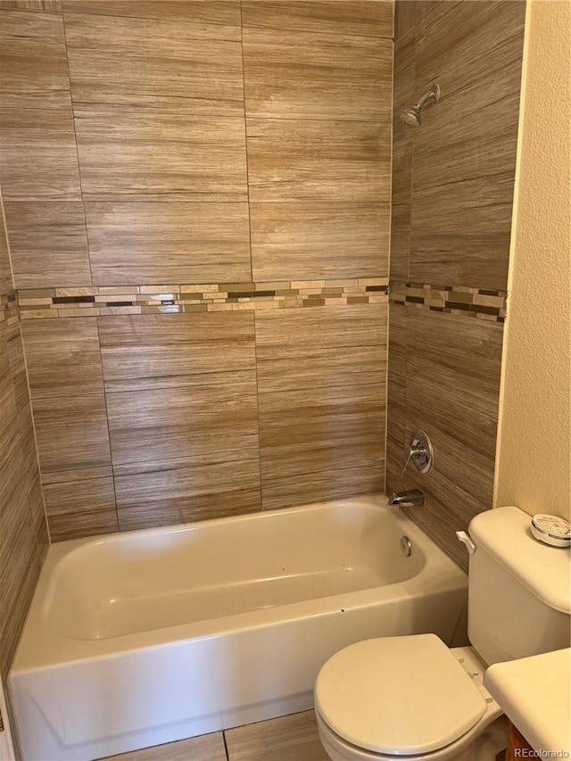 full bathroom with toilet, tiled shower / bath combo, and vanity