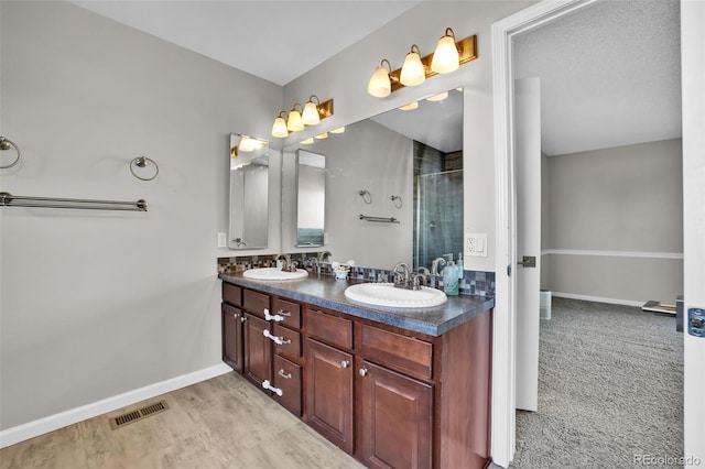 1065 Harbourne St, Colorado Springs, CO 80911 - bathroom with double vanity, a shower stall, and baseboards