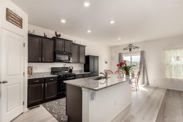 318 Thomas Ave, Keenesburg, CO 80643 - kitchen with black appliances, a sink, light wood-style floors, light stone countertops, and recessed lighting