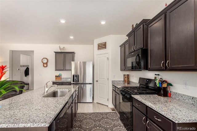 318 Thomas Ave, Keenesburg, CO 80643 - kitchen featuring black appliances, a sink, dark brown cabinetry, a kitchen island with sink, and recessed lighting