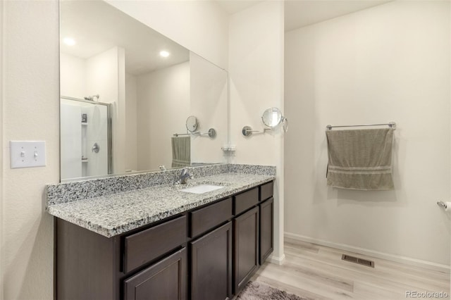 318 Thomas Ave, Keenesburg, CO 80643 - full bathroom featuring wood finished floors, vanity, baseboards, a shower, and recessed lighting