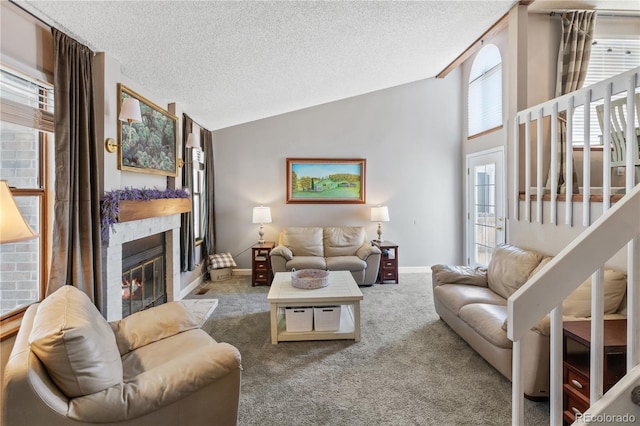 living room featuring lofted ceiling, carpet flooring, and a textured ceiling