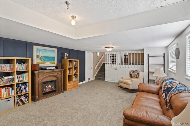 living room featuring carpet and a textured ceiling